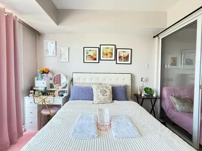 a bedroom with a large bed and a couch at Isla Cabana Azure Staycation in Manila