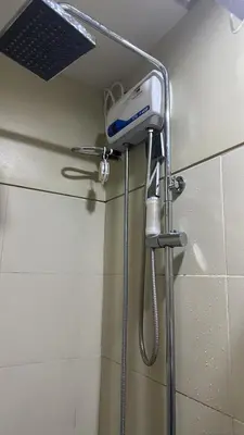 a shower with a blow dryer in a bathroom at One Bedroom Apartment near MOA in Manila