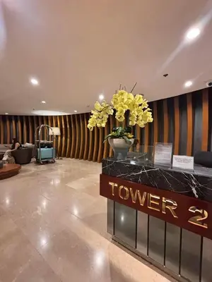 a lobby with a vase of yellow flowers on a counter at Shore 2 Residence in Manila