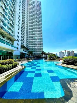 a large swimming pool in front of a tall building at Pixie Dust Suite in Manila