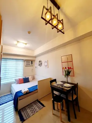 a bedroom with a bed and a table and a tableablish at Pixie Dust Suite in Manila
