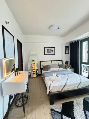 a bedroom with a bed and a sink and a mirror at ASD Airport Condotel Pasay in Manila