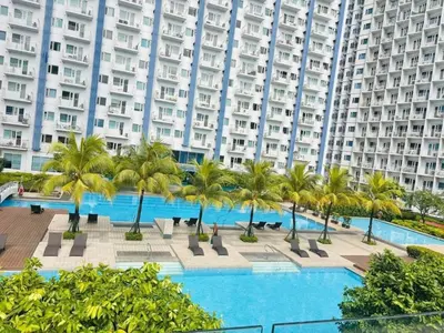 a pool with palm trees in front of a large building at Jazz Residences Makati Tower B in Manila