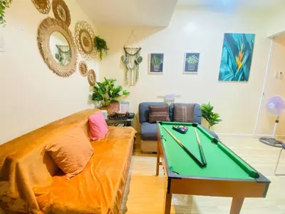 a living room with a couch and a pool table at Sole Sisters Staycation in Manila