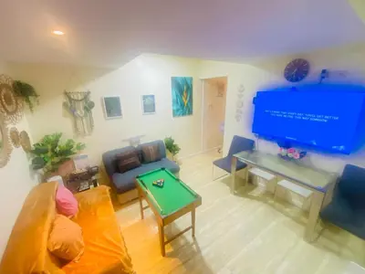 a living room with a large tv and a table at Sole Sisters Staycation in Manila