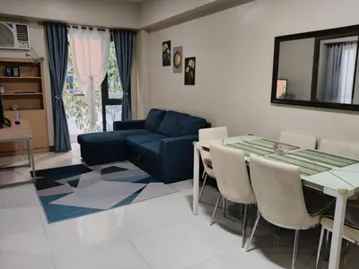 a living room with a table and a couch at LDN Two Palm Tree Villa LFamilia in Manila