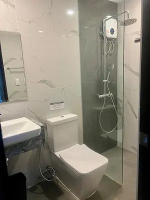 a bathroom with a shower and a toilet and a sink at 1 BR Executive Suite Gentry Manor by JMS in Manila