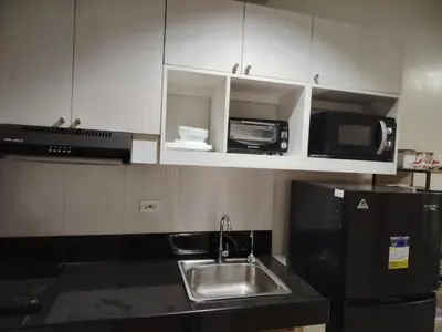a kitchen with a sink and a microwave at Charm Residences Building E in Manila