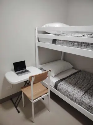 a bedroom with a desk and a laptop on a bed at Charm Residences Building E in Manila