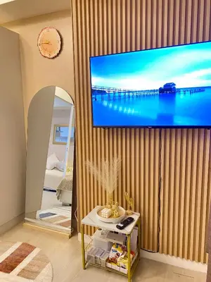 a living room with a large screen tv on a wall at Azure Staycation PH 1503 in Manila