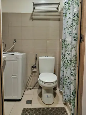 a bathroom with a toilet and a shower curtain at Shore Residences MOA Minimalist Room in Manila