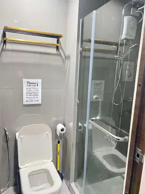 a bathroom with a toilet and a glass shower at Stylish Condo in Makati City with stunning views in Manila