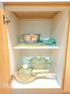 a cabinet filled with bowls and utensils at Azure Condotel and Resort in the City in Manila