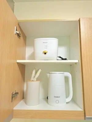 a cupboard with two cups and a blender at Azure Condotel and Resort in the City in Manila
