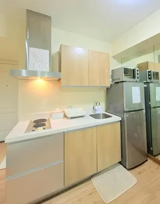 a kitchen with a sink and a refrigerator at Azure Condotel and Resort in the City in Manila