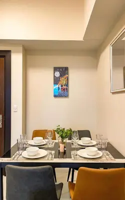 a dining room with a table and chairs at Cozy 2BR Suite in Uptown BGC with PS4 and walking distance to Malls and Restaurants in Manila