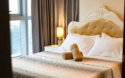 a bedroom with a large bed with a large headboard at Cozy 2BR Suite in Uptown BGC with PS4 and walking distance to Malls and Restaurants in Manila