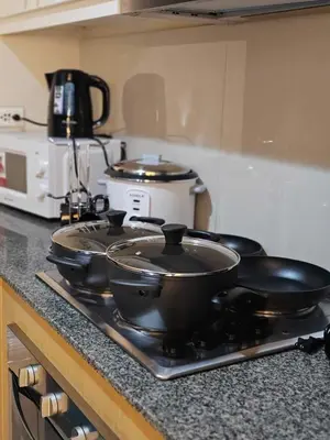 two pans sitting on top of a stove in a kitchen at Spacious 3BR Suite in Uptown BGC with King Size Bed, near Malls and Restaurants in Manila