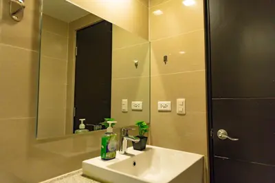 a bathroom with a sink and a mirror at Spacious 3BR Suite in Uptown BGC with King Size Bed, near Malls and Restaurants in Manila