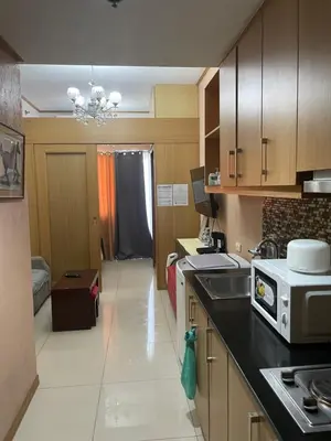 a kitchen with a sink and a microwave at 1528 pool view with balcony in Manila