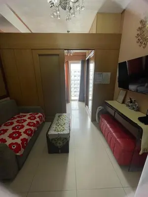 a living room with a bed and a couch at 1528 pool view with balcony in Manila