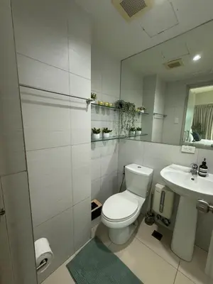 a white bathroom with a toilet and a sink at Palms Paradise with the best view of BGC plus Netflix in Manila