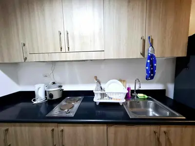 a kitchen with a sink and a counter top at Wooden style amenities view in Manila