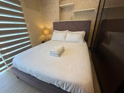 a bed with a towel on it in a bedroom at Deluxe Suite in Venice Mall in Manila