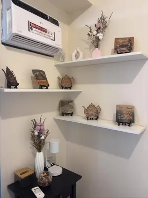 a room with shelves with flowers and a table at Bless View at 16th in Manila