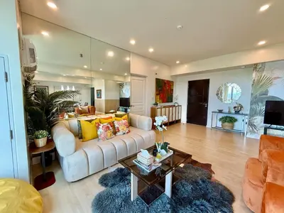 a living room with a couch and a table at Spacious Tropics with Golf View in BGC in Manila