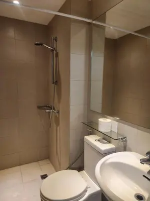 a bathroom with a shower and a toilet and a sink at Azure Staycation Philippines by AMRS Near Manila International Airport in Manila