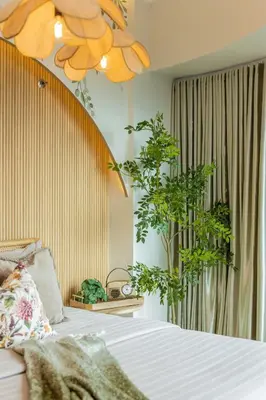 a bedroom with a bed and a potted plant at Tropical Sunset w the best view in BGC plus Netlfix in Manila