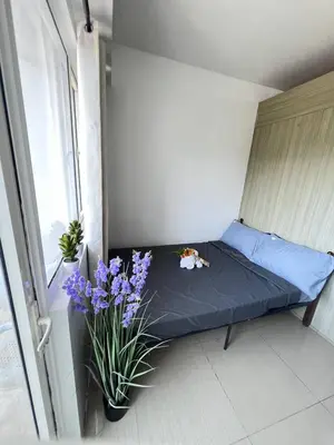 a small bed in a room with purple flowers at Unistay SHORE Residence w Balcony Amazing Manila Bay view near MOA in Manila