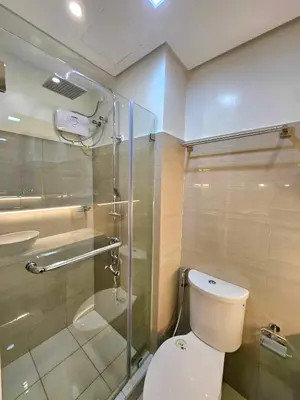 a bathroom with a toilet and a glass shower at Serenity Suite in Manila
