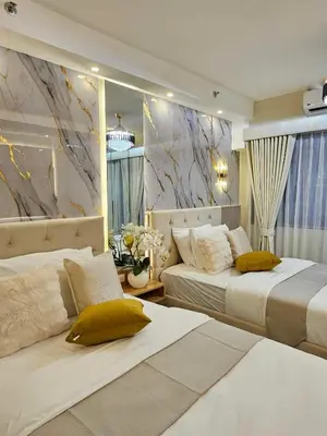 a bedroom with two beds and a marble wall at Serenity Suite in Manila