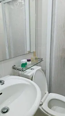 a bathroom with a sink and a toilet and a mirror at Cozy Apartment Azure Urban Resort Residences in Manila