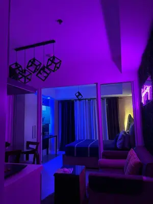 a living room with purple lighting and a couch at Azure Urban Resort Residences - Staycationary Miami 1710 in Manila