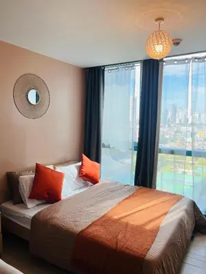 a bedroom with a bed with orange pillows and a window at BGC Simple Elegant 300Mbps Wifi,Pool,Netflix in Manila