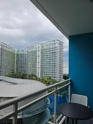 a balcony with a view of a large building at Cozy Apartment Azure Urban Resort Residences in Manila