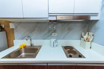 a kitchen counter with a sink and a stove at City of Dreams Luxury Makati 5637 Swim Gym Netflix Superfast Surfing in Manila