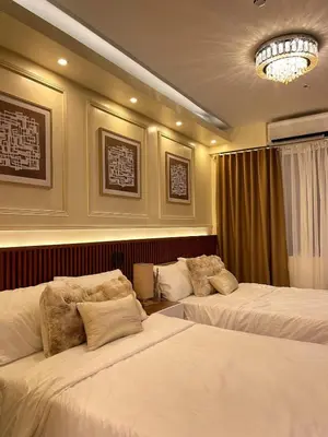 a hotel room with two beds and a chandelier at Belfort Suite by Crib2GO in Manila