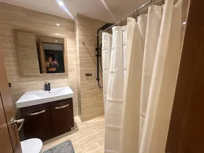a bathroom with a white shower curtain and a sink at Cozy Laura at ACE Plaza in Manila