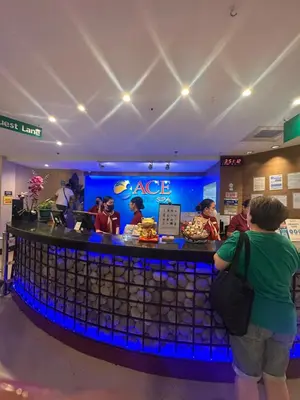 a group of people standing at a bar in a store at Cozy Laura at ACE Plaza in Manila