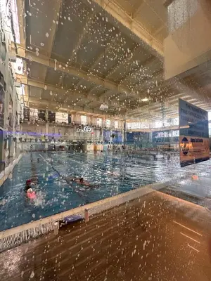 a large swimming pool with people swimming in it at Cozy Laura at ACE Plaza in Manila