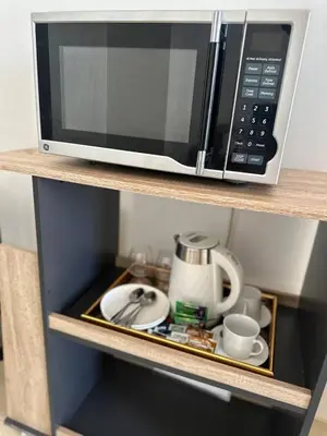 a microwave sitting on top of a shelf at Cozy Laura at ACE Plaza in Manila