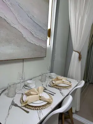 a white table with plates and napkins on it at Casa y' Bonita MOA Pasay Staycation in Manila