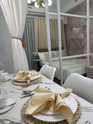 a dining room with a table with plates and napkins at Casa y' Bonita MOA Pasay Staycation in Manila