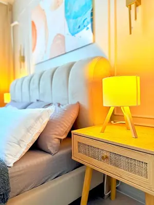 a couch with pillows and a lamp on a table at The Carly Suite in Manila