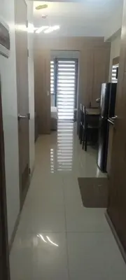a hallway of a room with a kitchen and a table at Staycation Modern & Convenient in Tubigan
