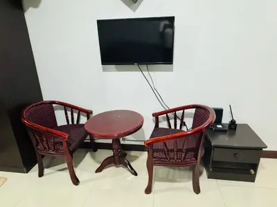 a room with two chairs and a table and a tv at Stamford Residences Fully-furnished in Manila